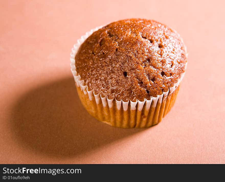 Chocolate muffin on brown background