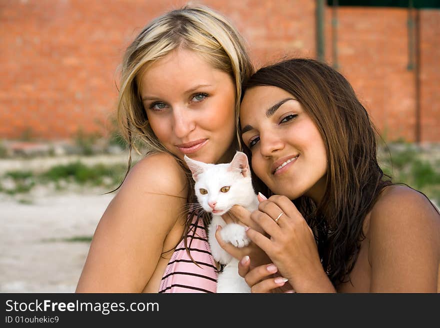 The girls with a kitten on a beach. The girls with a kitten on a beach