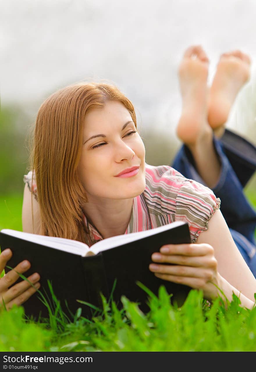 Pretty young woman reading outdoors. Pretty young woman reading outdoors