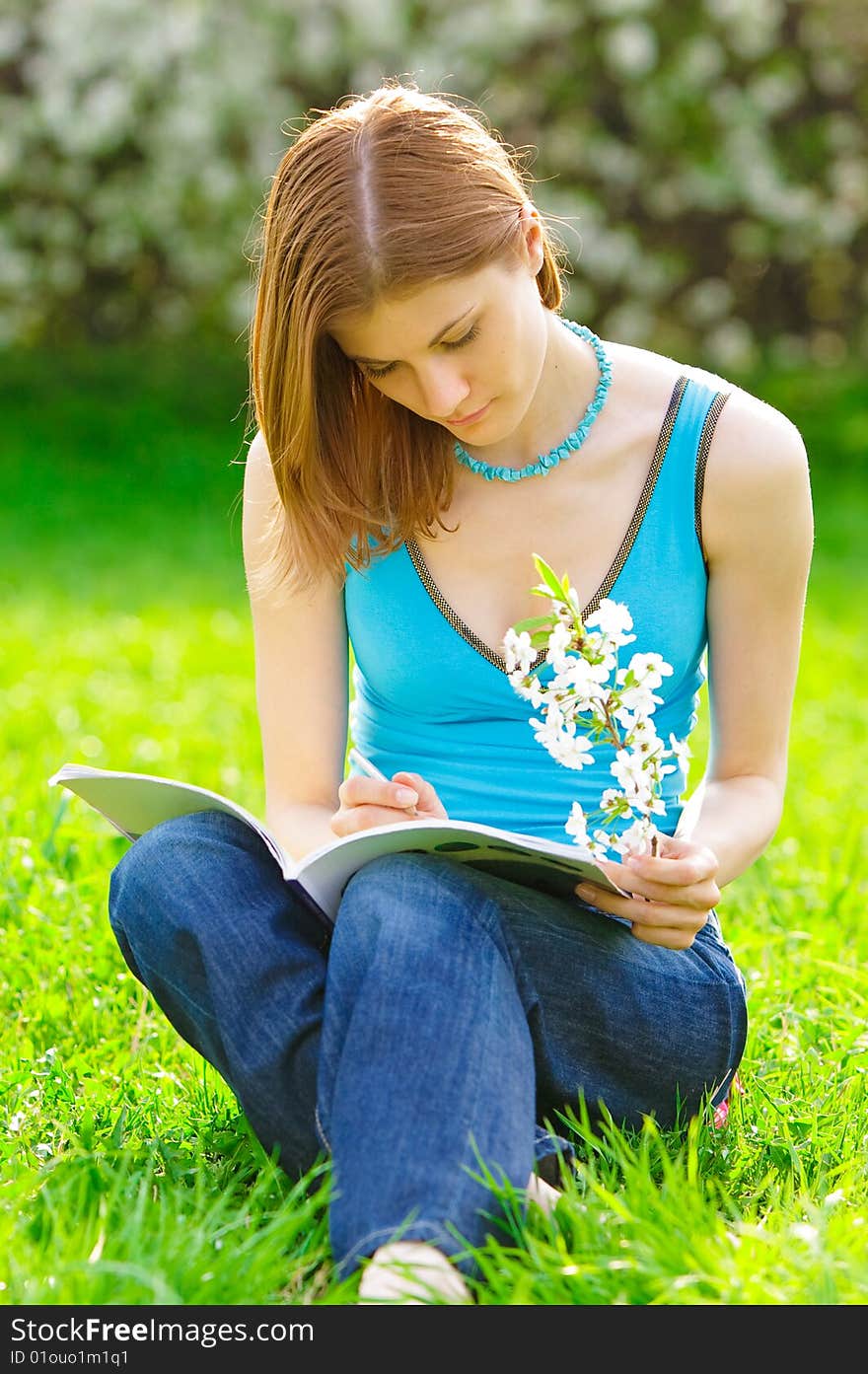 Pretty student with a flower studying outdoors. Pretty student with a flower studying outdoors