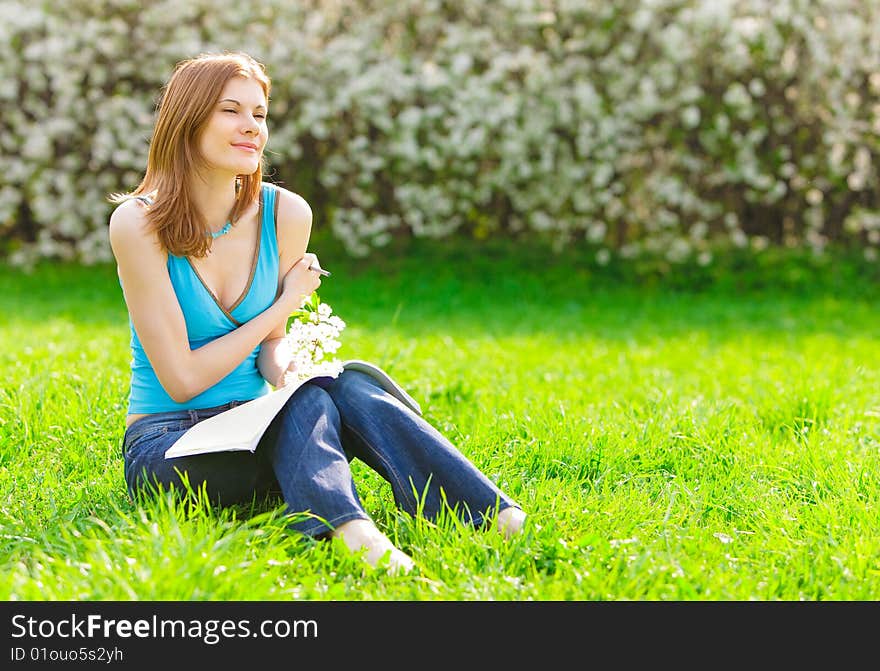 Pretty student with a flower studying outdoors. Pretty student with a flower studying outdoors