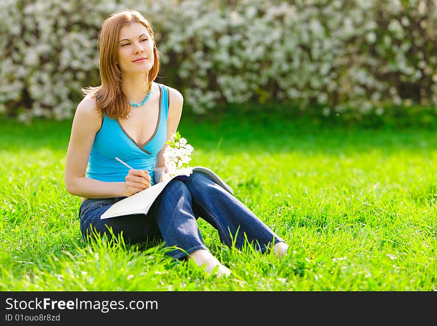 Pretty student with a flower studying outdoors. Pretty student with a flower studying outdoors