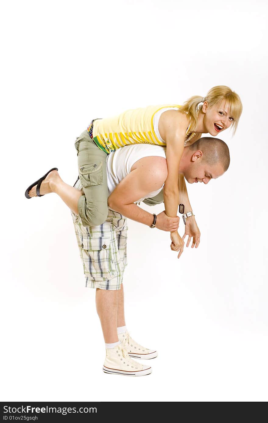 Young man holding his girlfriend in the air on his back