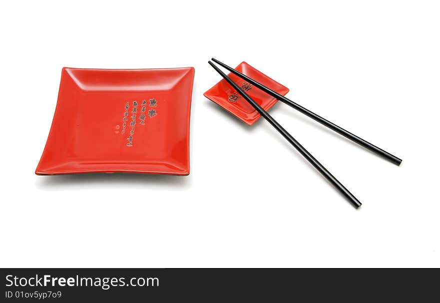 Chopsticks, red square plate and saucer isolat