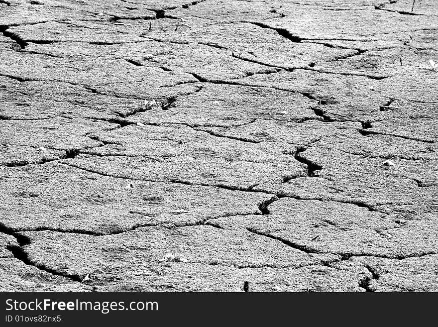 This is a black and white photograph. Dry land gives the feeling of desire for water.