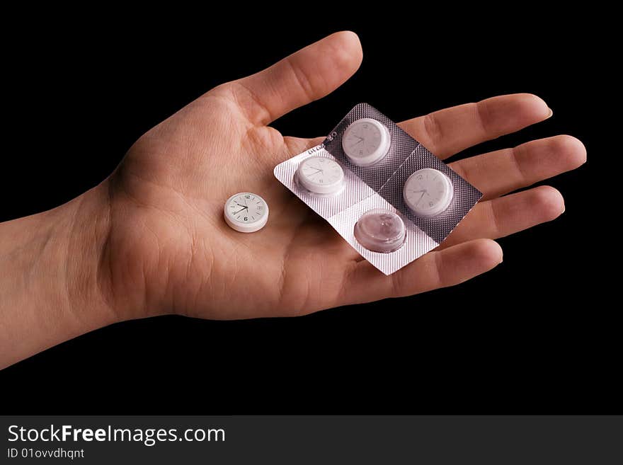 Hand with pills as a watch over black (Time is a great healer)