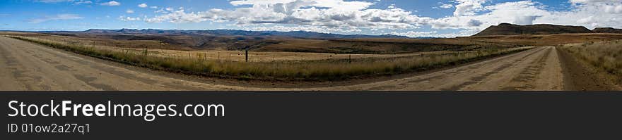 A panaroma of the tail of the Drakensberg mountain range on a dusty farm road this is in the Eastern Cape in South Africa. A panaroma of the tail of the Drakensberg mountain range on a dusty farm road this is in the Eastern Cape in South Africa