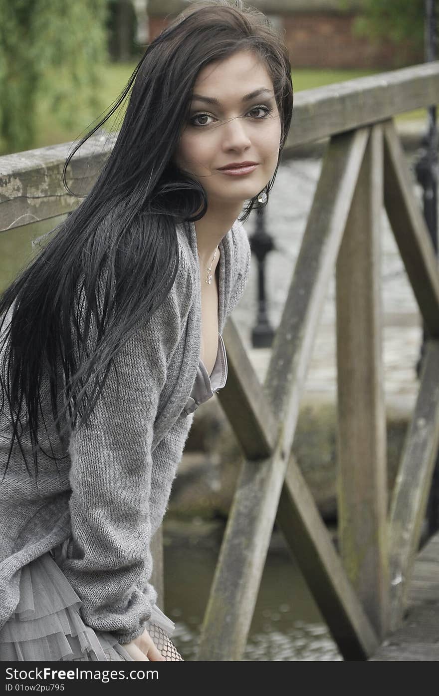 Dark-haired young woman on the old  bridge