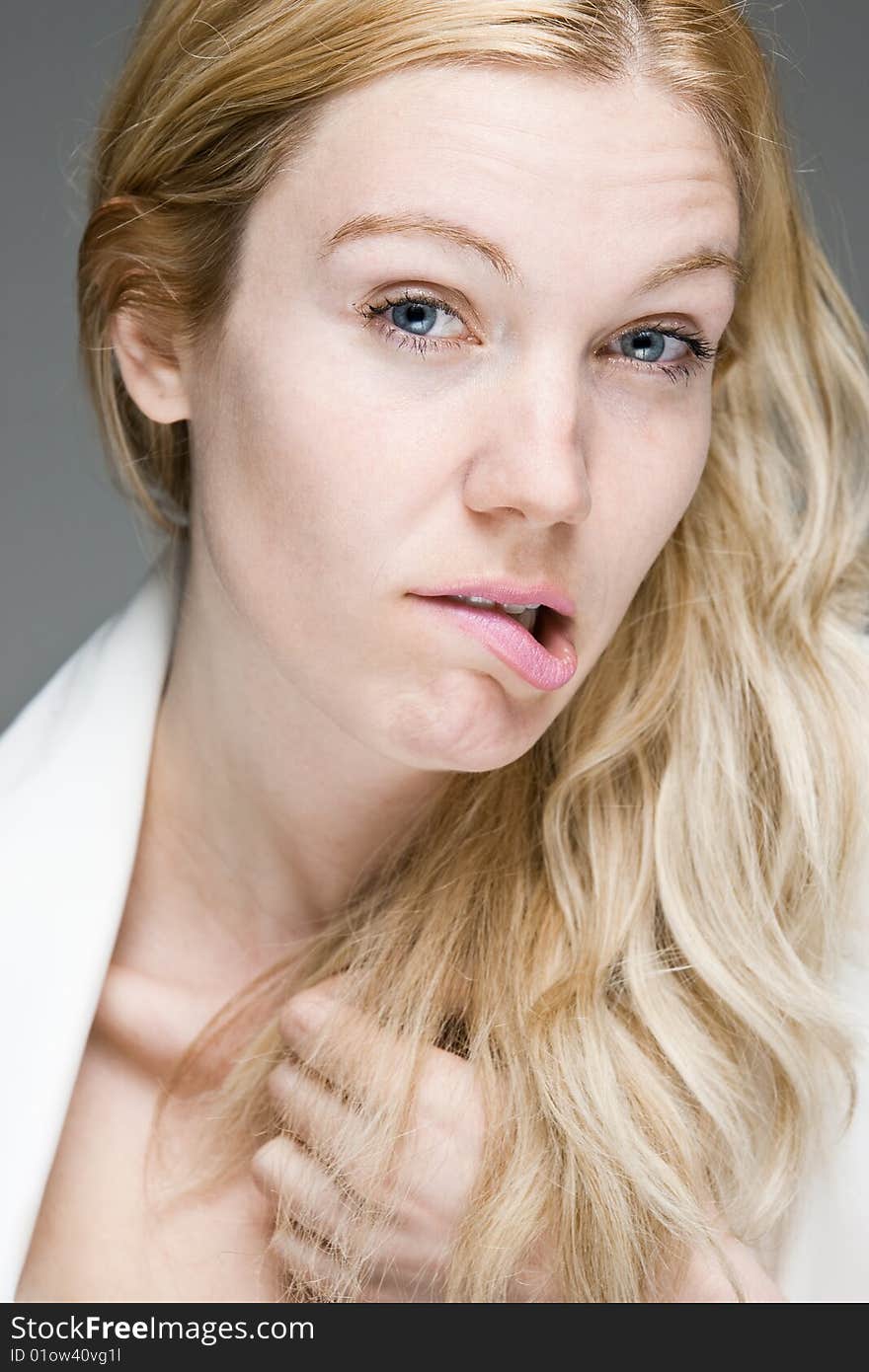 A young woman with a worried look biting her lip. A young woman with a worried look biting her lip.