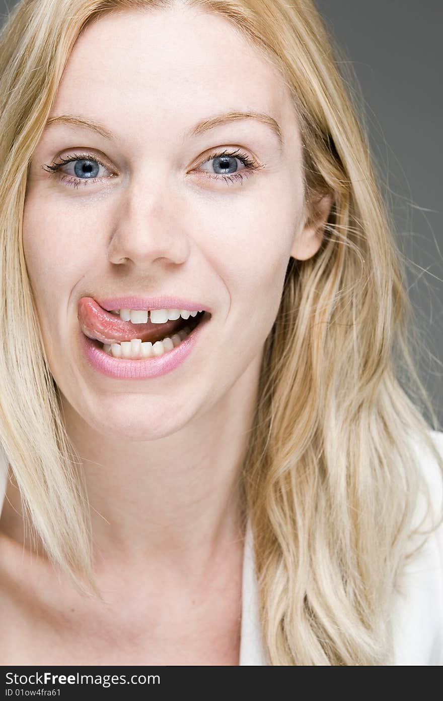 A blonde woman licking her lips at something tasty. A blonde woman licking her lips at something tasty.