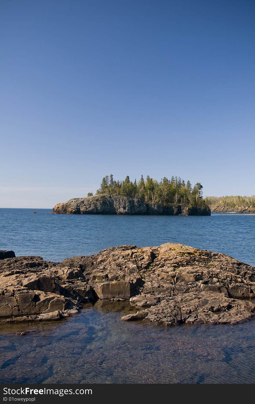 A tree covered island offshore in Lake Superior. A tree covered island offshore in Lake Superior.