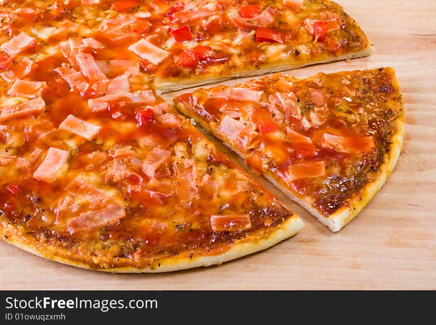 Hot sliced pepperoni pizza on wooden chopping board