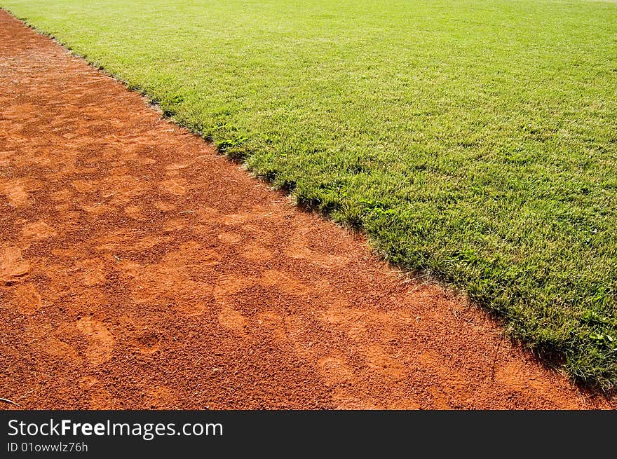 Grass and red running cinder in diagonal