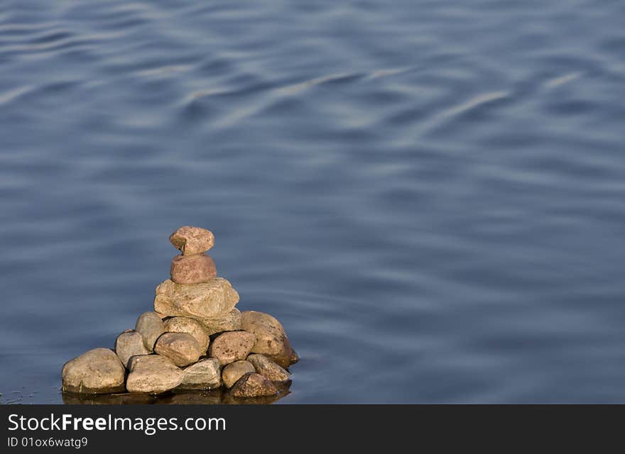 Pyramid of stones on a background surface of the water