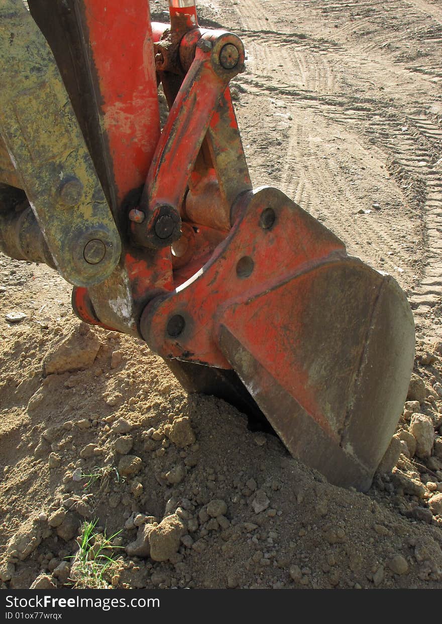 The shovel of a large bulldozer digs into the ground. The shovel of a large bulldozer digs into the ground.