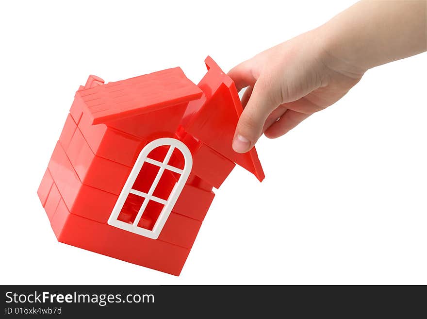 A child's hand holding a doll`s house made of plastic details for designing on a white background. A child's hand holding a doll`s house made of plastic details for designing on a white background