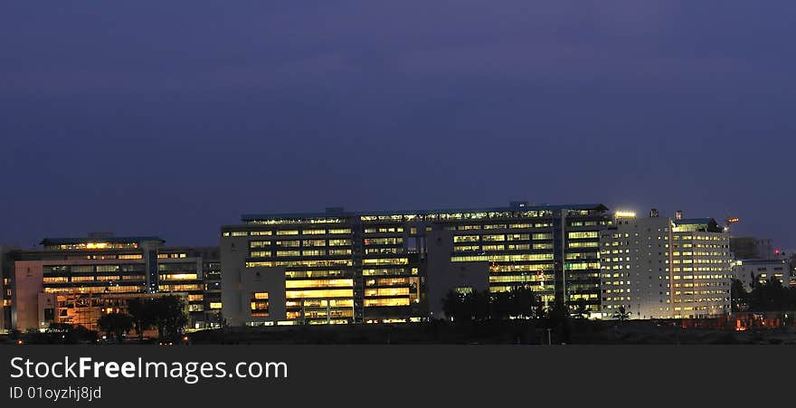 Panoramic view of an office building brightly lit at evening time. Panoramic view of an office building brightly lit at evening time.