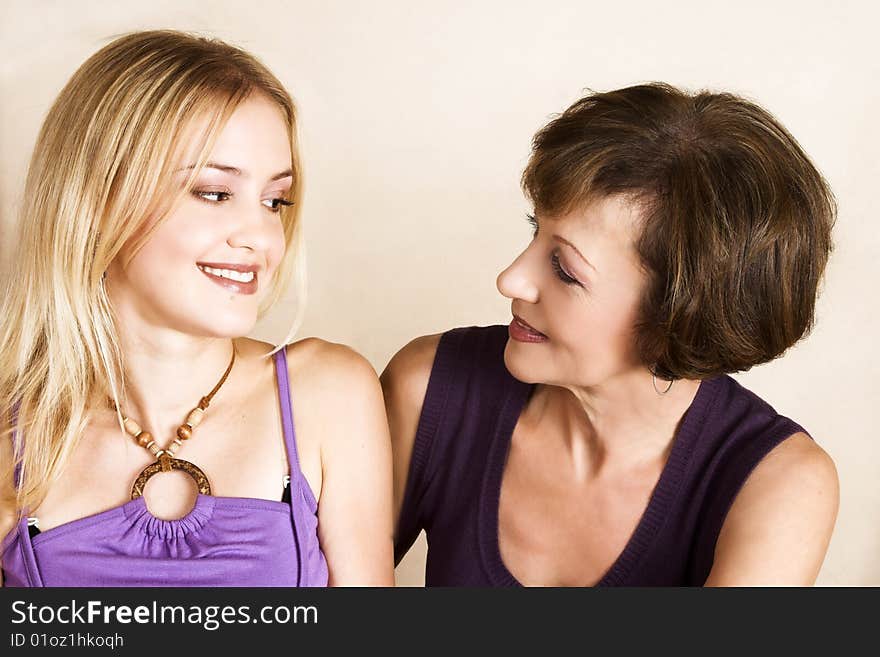 Beautiful mother and daughter against a light background