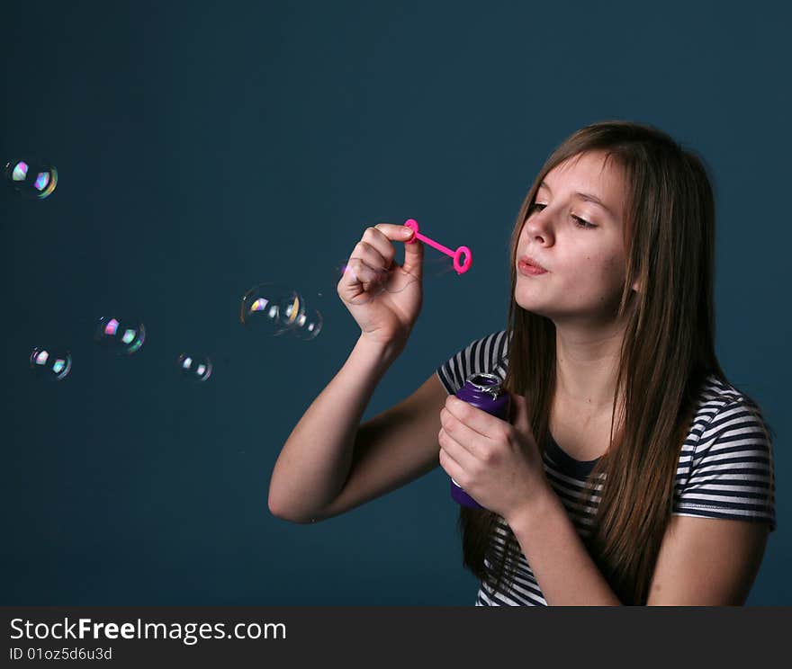 Studio portrait of pretty girl blowing bubbles