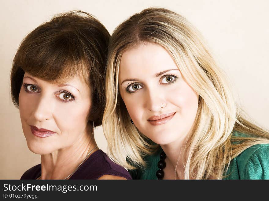 Beautiful mother and daughter against a light background