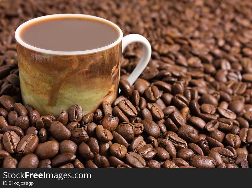 Cup of coffee between coffee beans