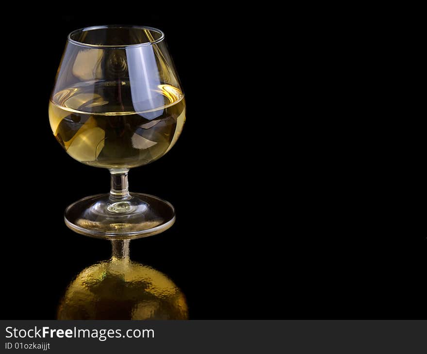 One glass white wine on black background, with room for text.