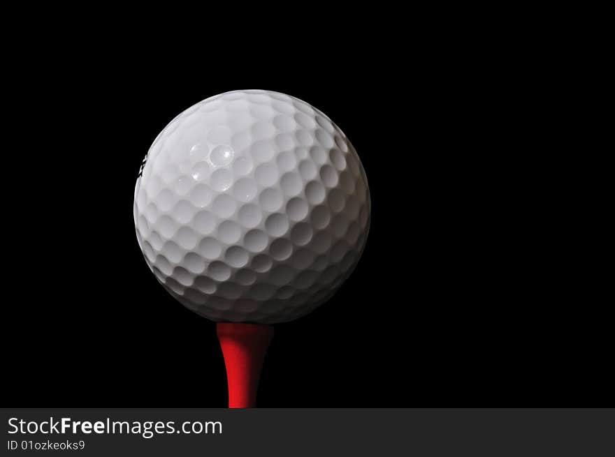 Golf ball and tee isolated on black - clipping path included. Golf ball and tee isolated on black - clipping path included