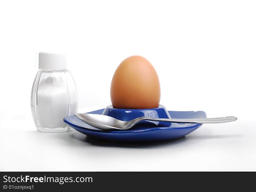 Egg standing.cardboard egg support with salt.brown egg on a white background.