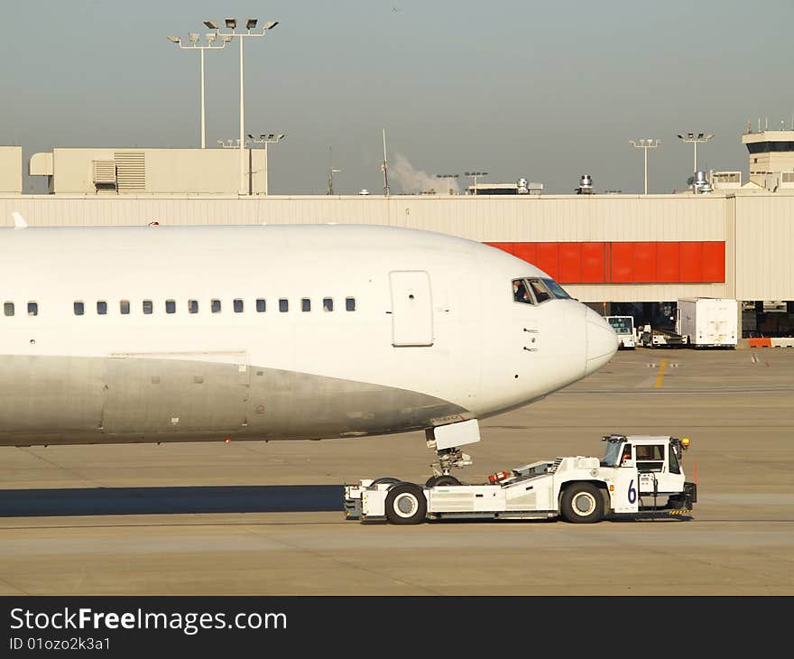 Passenger airplane being pulled at airport. Passenger airplane being pulled at airport