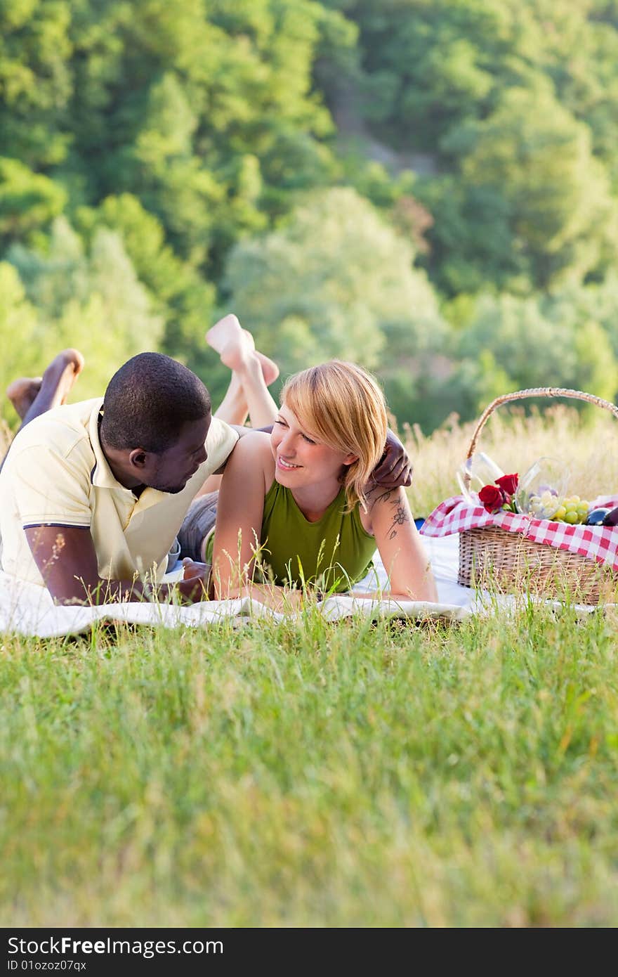 Portrait of young multiethnic couple picnicking in park