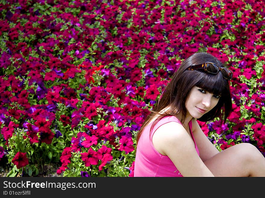 Beautiful woman wearing sun glasses with a background of purple flowers. Beautiful woman wearing sun glasses with a background of purple flowers