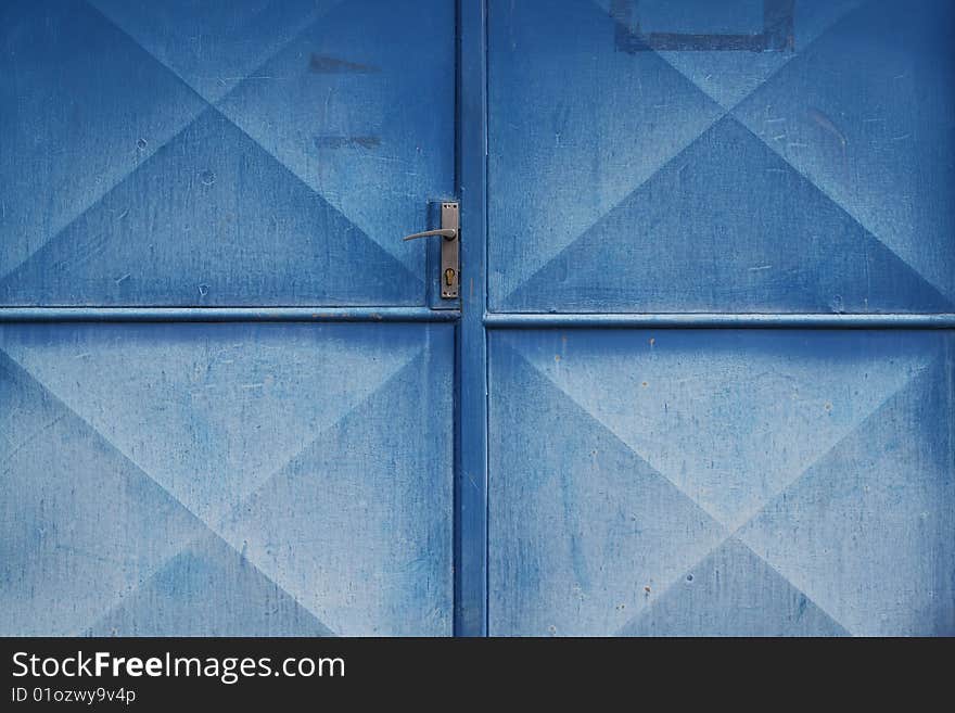 Old garage door with nicely diluted blue colour, frame fully filled, possible to use like a background or wallpaper.