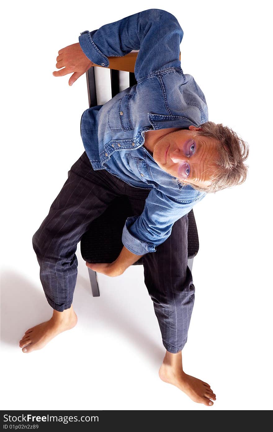 Casual man shoeless sitting on a chair and looking up. Casual man shoeless sitting on a chair and looking up