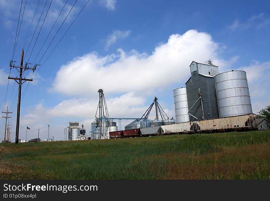 Grain elevator buildings along railroad track in midwest.