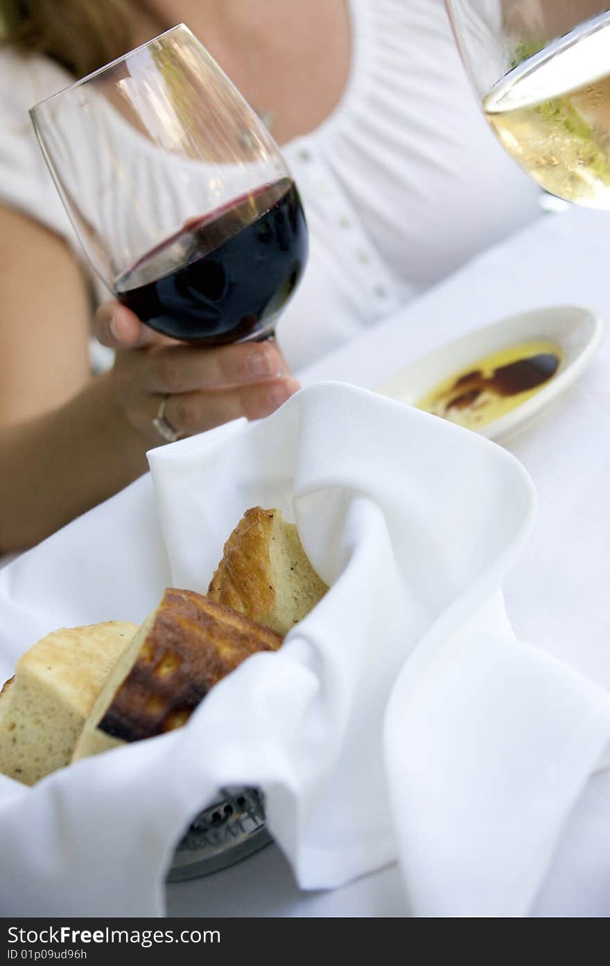 Bread basket at a table setting with wine and dipping oil. Bread basket at a table setting with wine and dipping oil