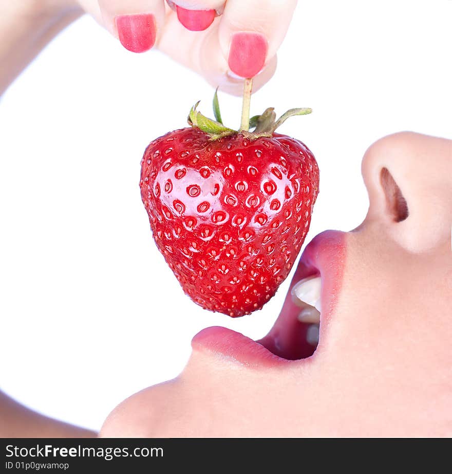 Brunette girl eating a strawberry