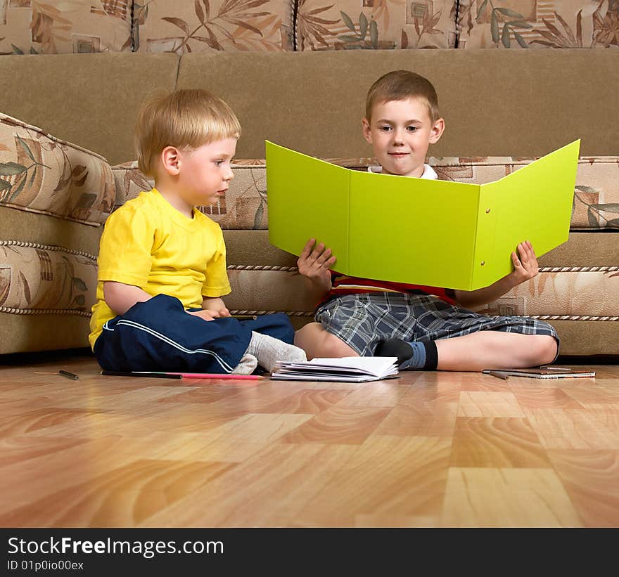 Two small boys are engaged at home on a floor. Two small boys are engaged at home on a floor