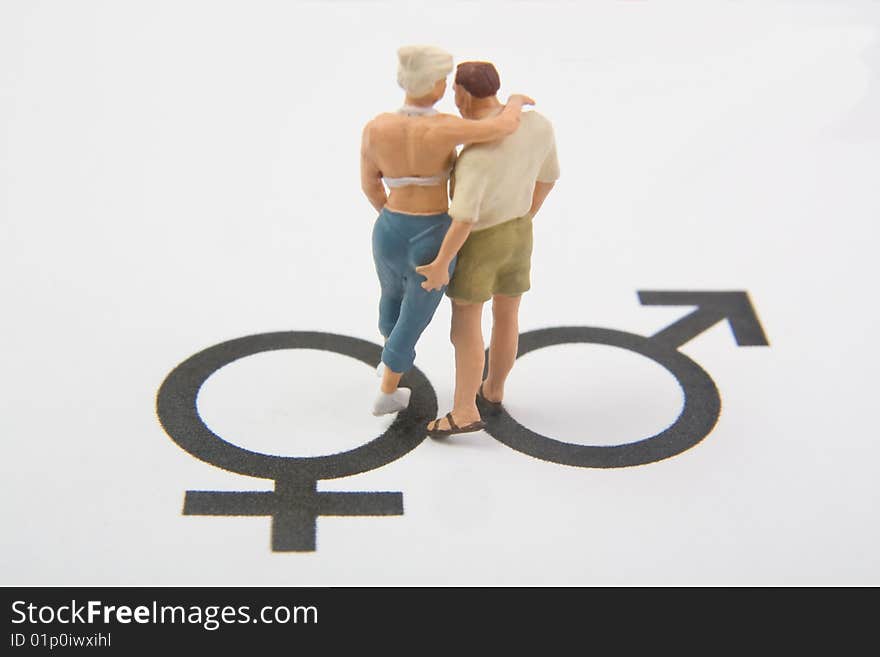 Miniature man and woman on male and female symbols