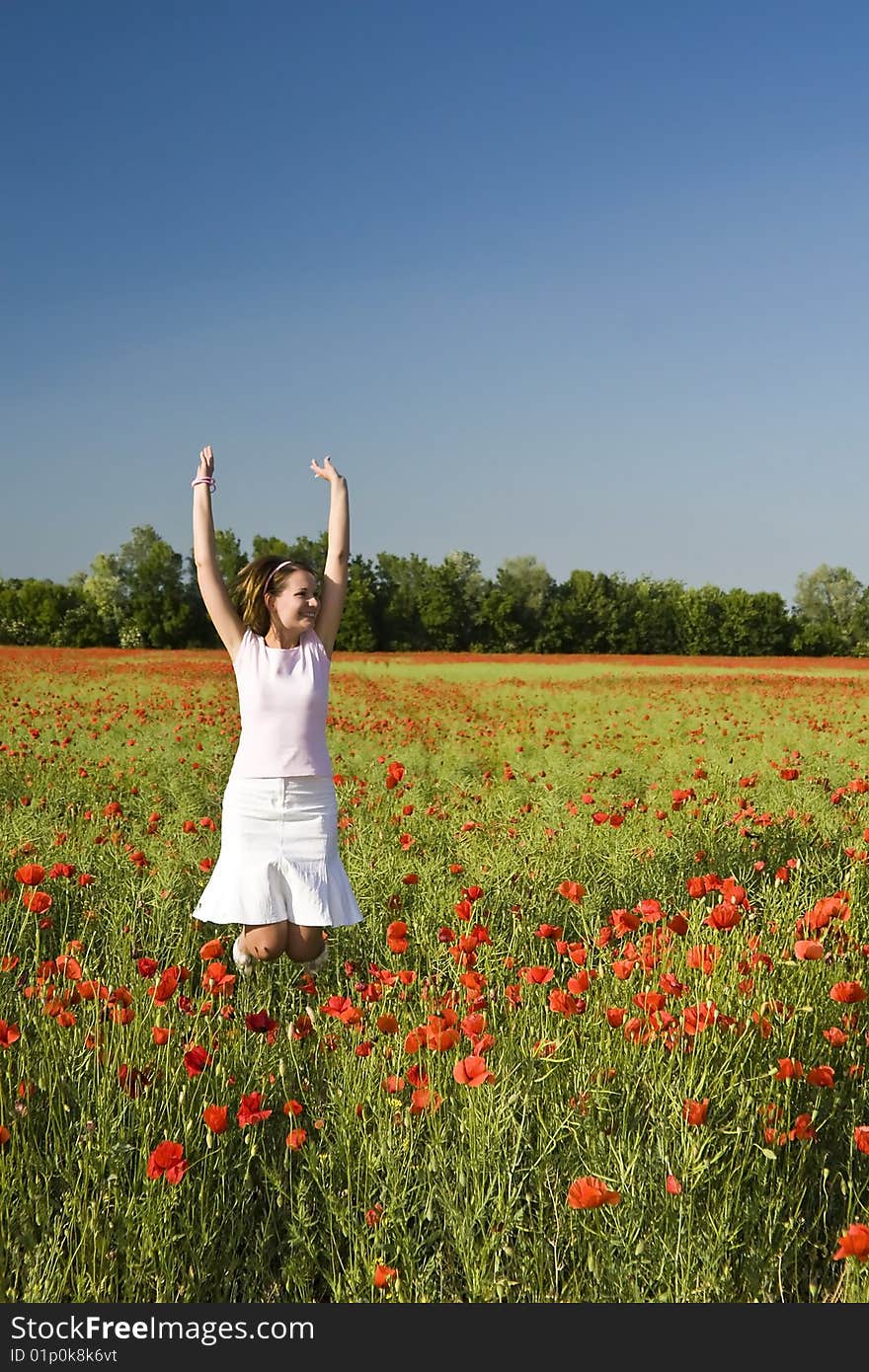 A beautiful woman feels happy on the poppy field. A beautiful woman feels happy on the poppy field.