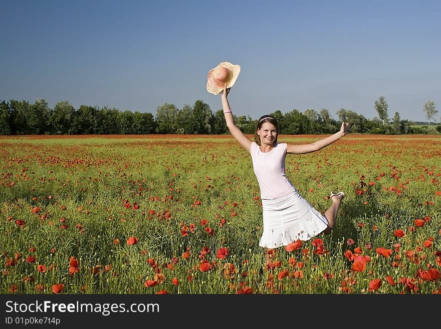 A beautiful woman feels happy on the poppy field. A beautiful woman feels happy on the poppy field.