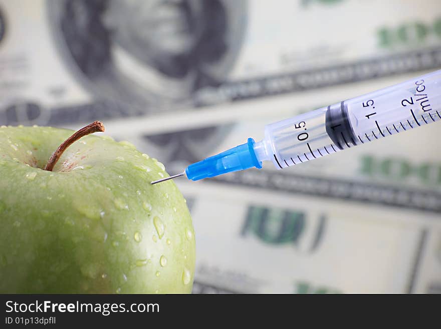 Injection in an dreen apple. Focus on needle. Injection in an dreen apple. Focus on needle.