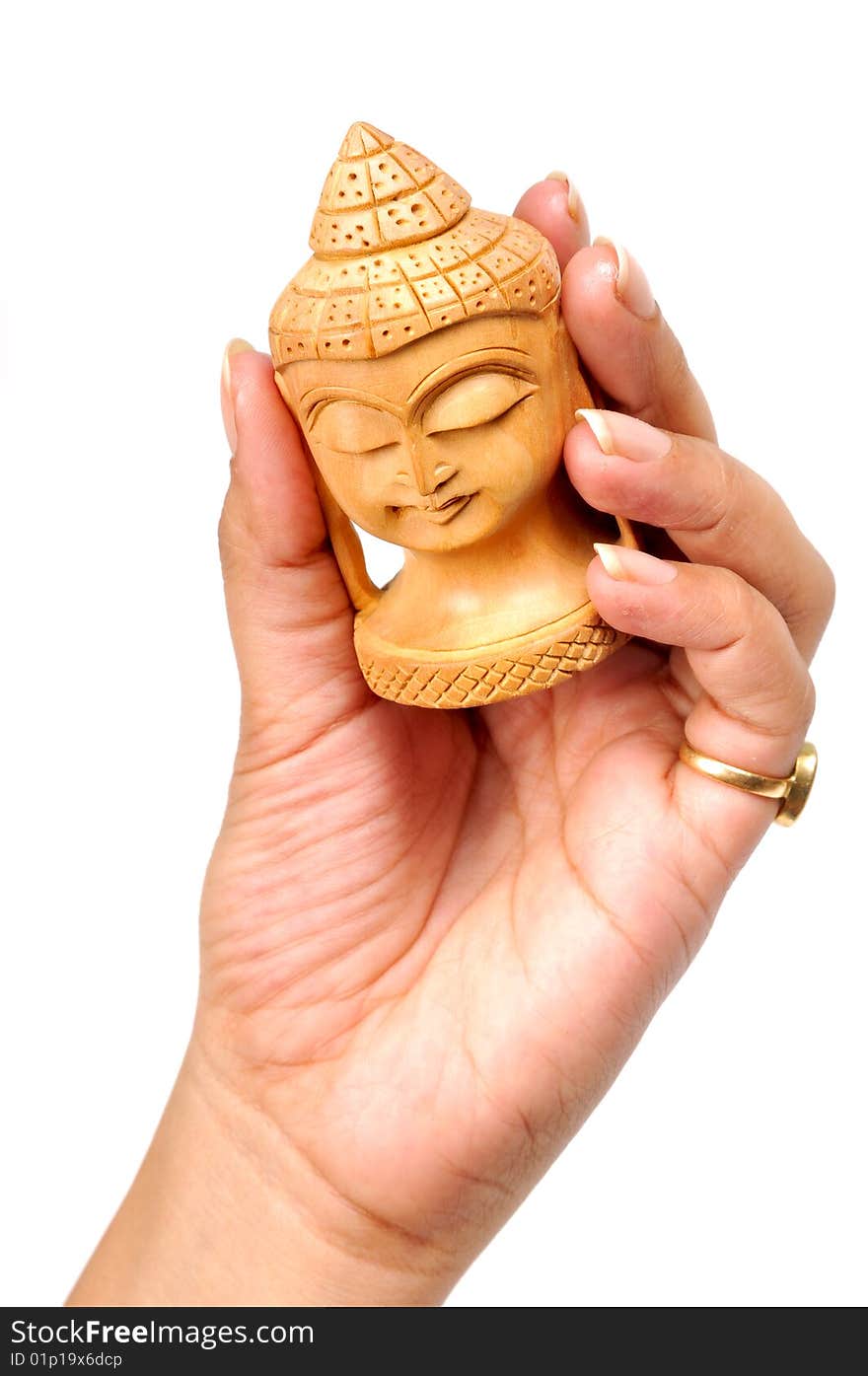 Wooden buddha face in femal's hand isolated on white background.