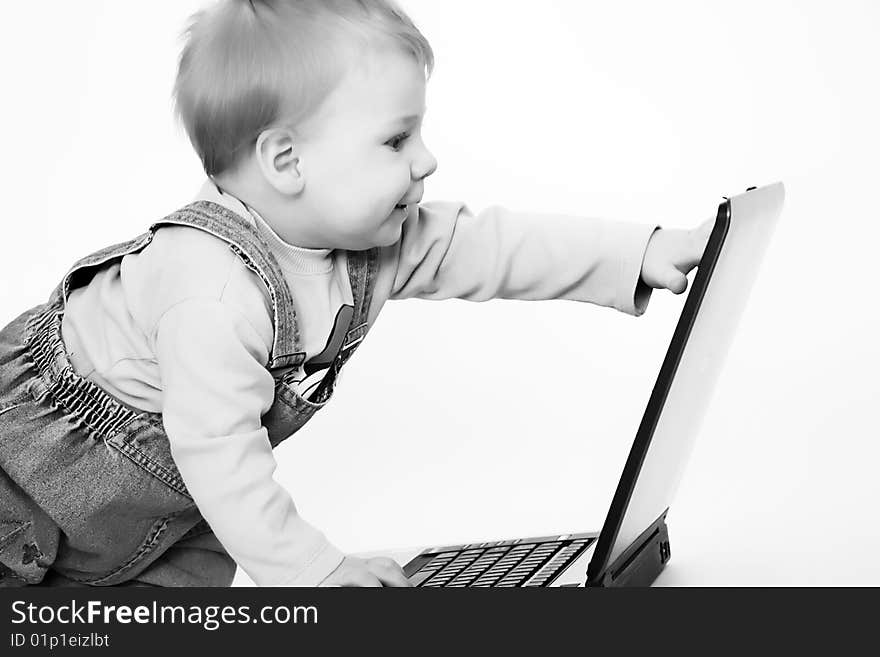 The happy dressed child look at the screen laptop. The happy dressed child look at the screen laptop