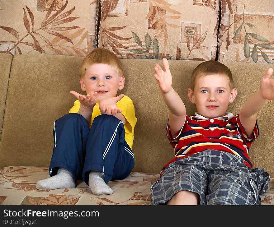 Portrait of two boys laying on a sofa of the house