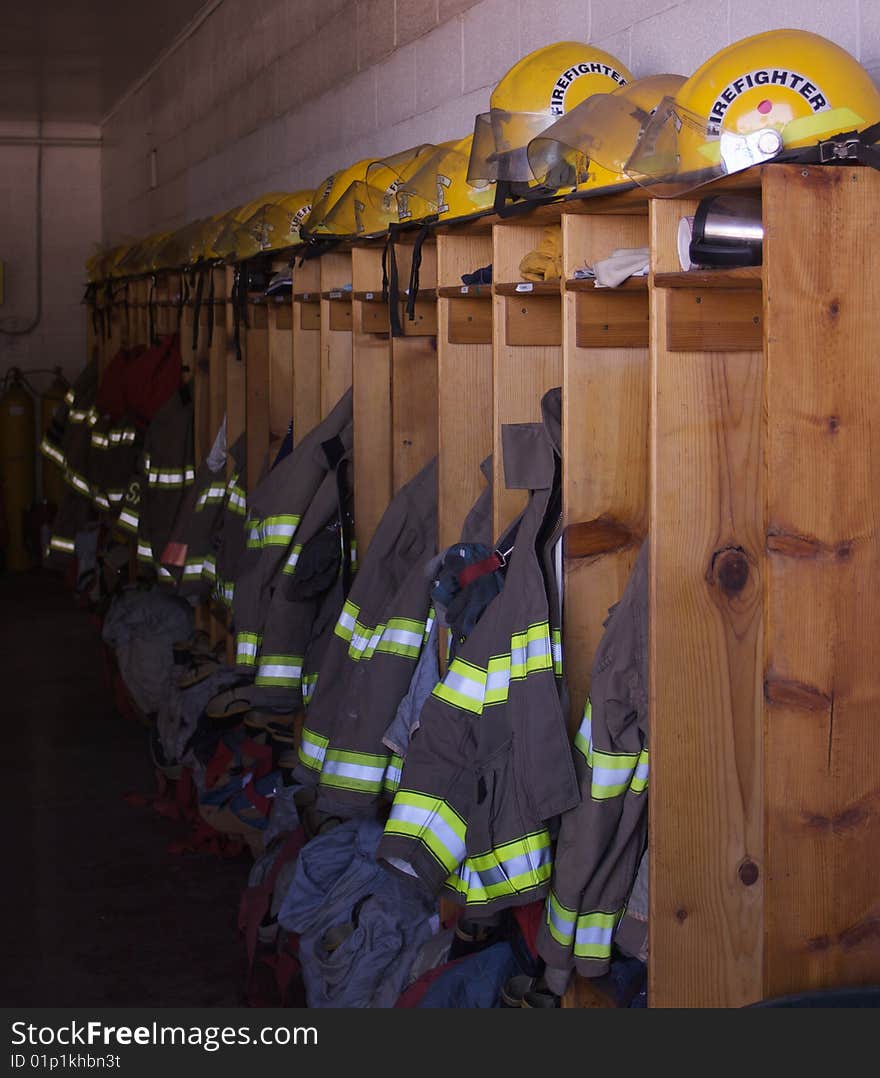 A row of lockers in a firehouse with jackets and helmets. A row of lockers in a firehouse with jackets and helmets