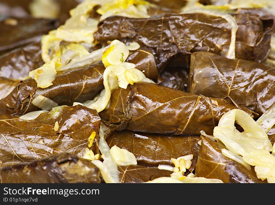 Full shot of stuffed Grape leaves with sauteed onions that fill the image. Full shot of stuffed Grape leaves with sauteed onions that fill the image.