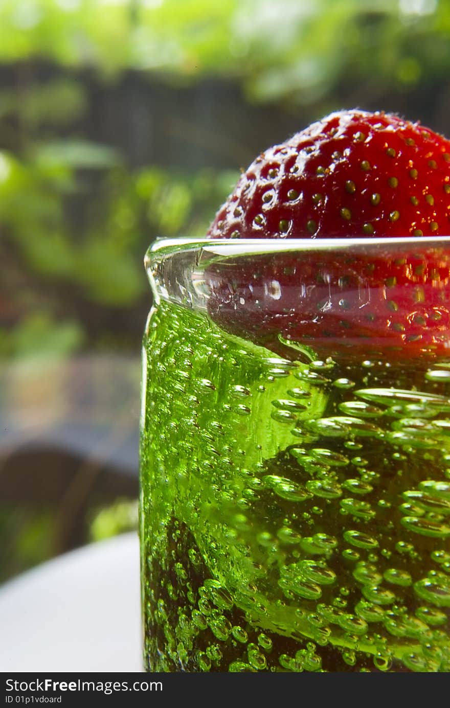 One strawberry in glass, of alcohol