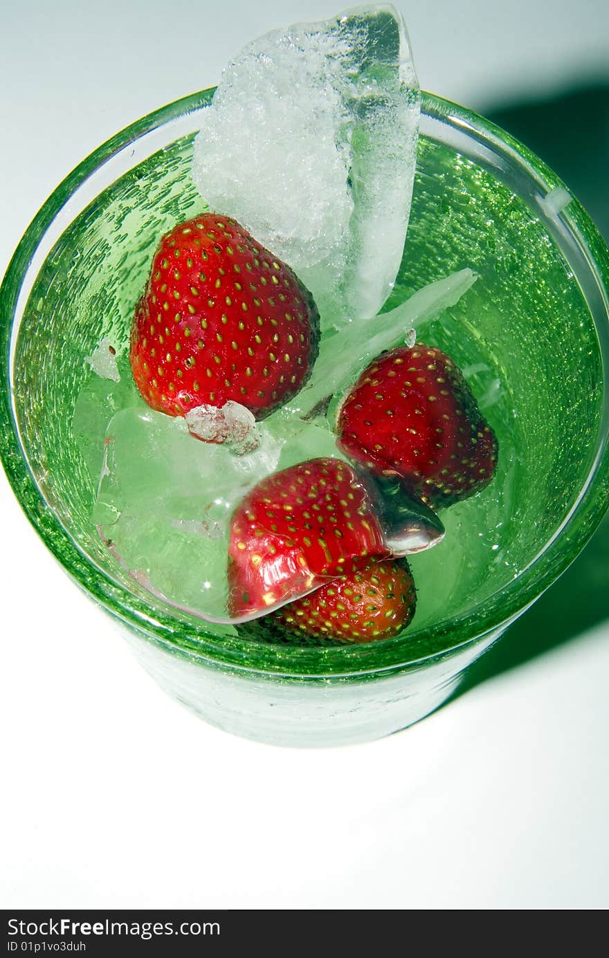 Strawberry drink in green glass with ice