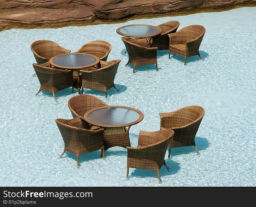 Restaurant on water, wicker chairs and glass tables