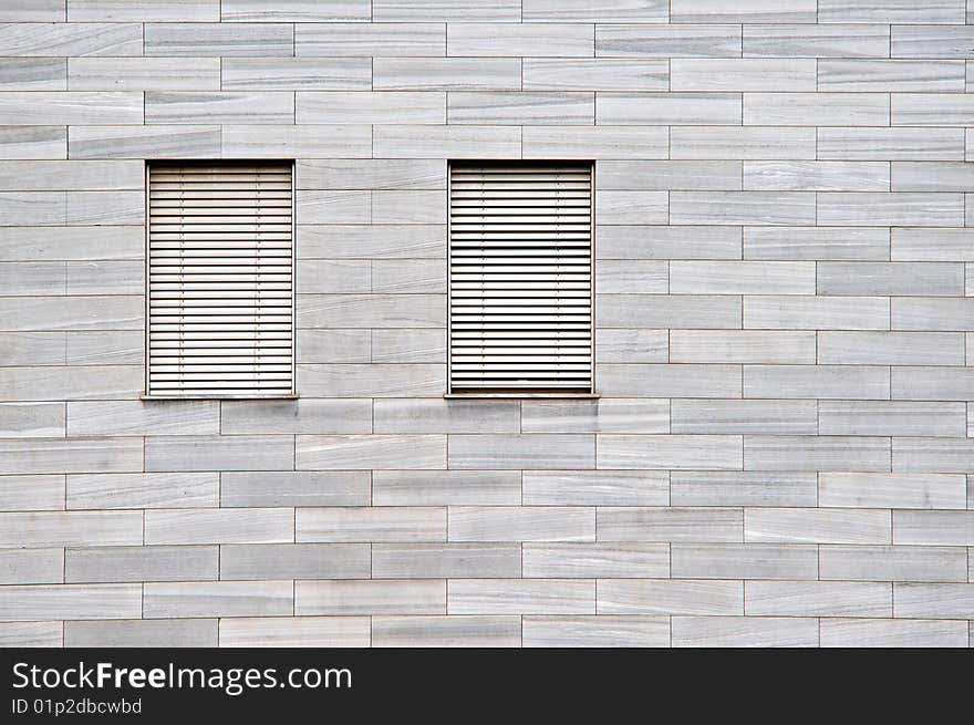 Two windows with roles and stones facade. Two windows with roles and stones facade